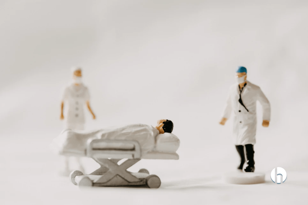 Figurine doctors and patient in hospital bed