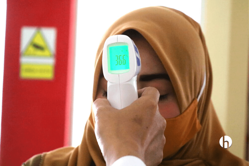 Woman having her temperature checked